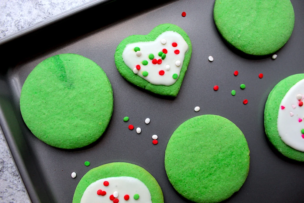A sheet pan of grinch cookies displays from above the adorable decorations done by my grinch-loving kids.